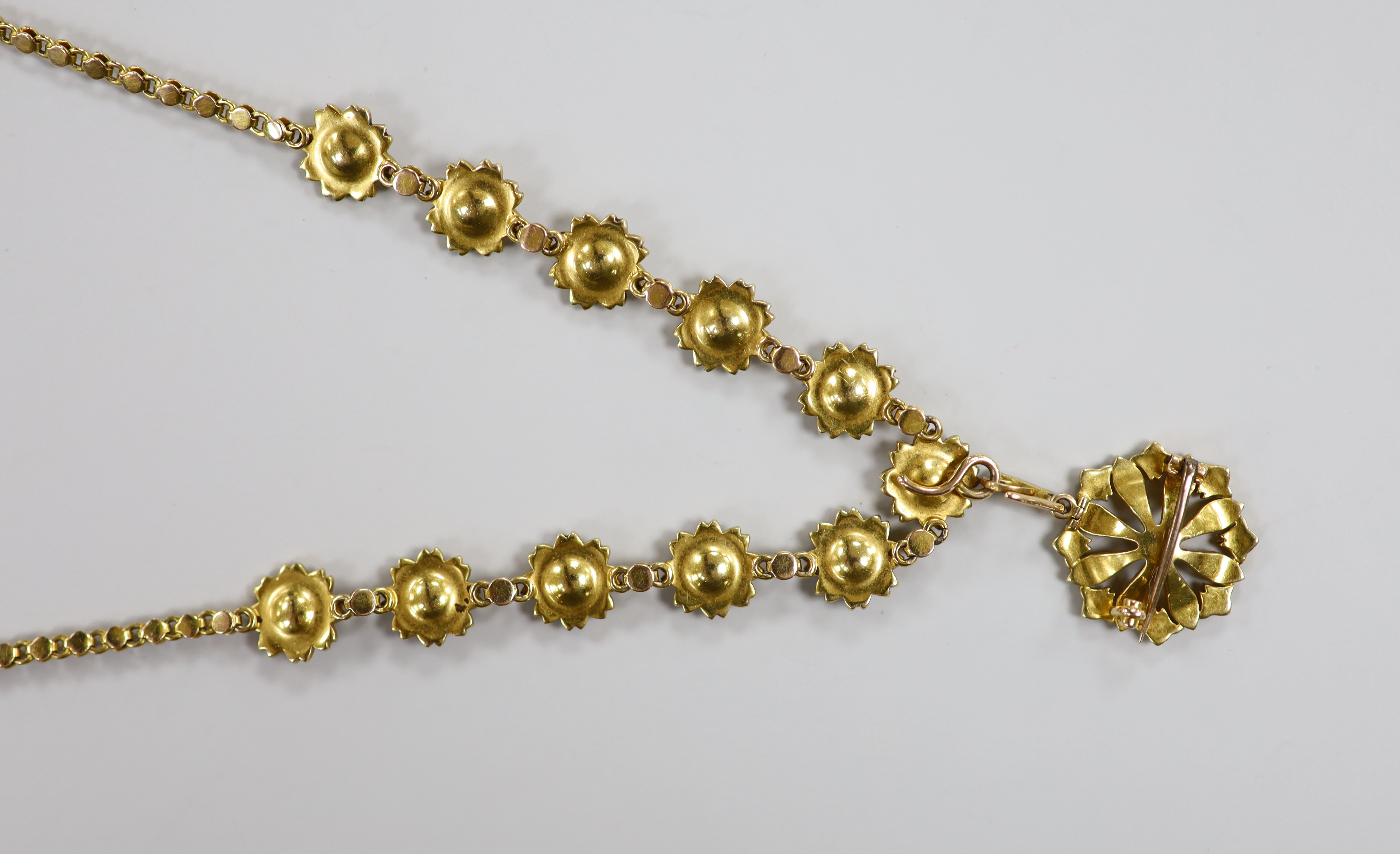 An Edwardian yellow metal and seed pearl set pendant brooch necklace, with flower head motifs, 43cm, gross weight 23.4 grams.